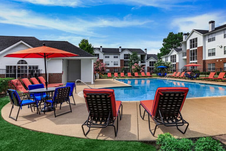 The Reserve at Harper's Point apartments pool with tables and chairs.